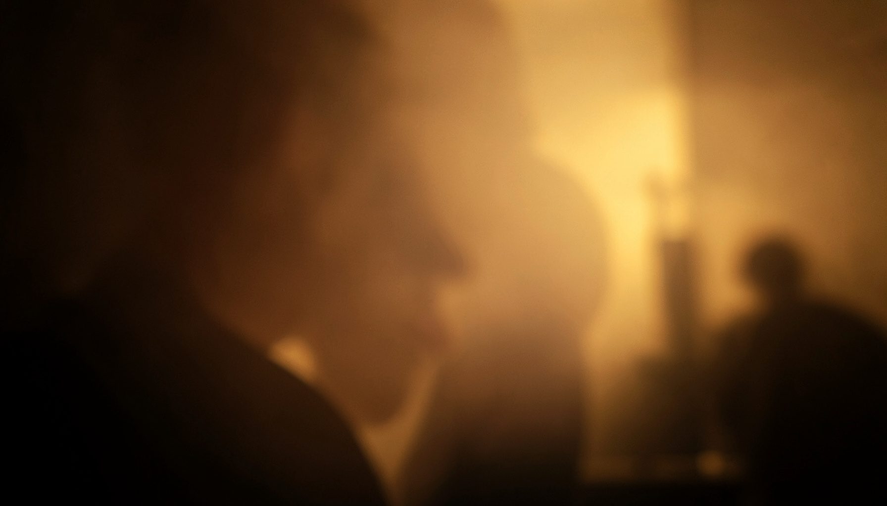 Intimate backstage moment with warm tungsten glow and soft shadows
