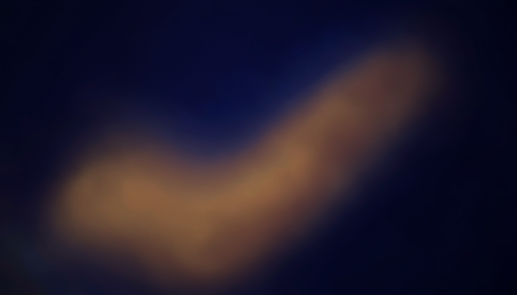A warm, atmospheric composition of deep indigo and amber tones blending softly across a wide frame, evoking the focused energy of a professional studio space
